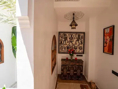 a hallway with a table and a painting on the wall at Riad Le Nid De Fatima in Marrakech