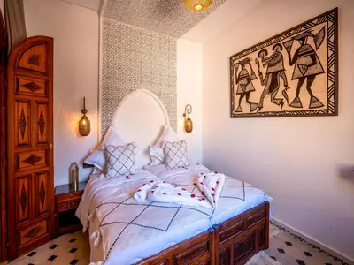 a bedroom with a bed with a picture on the wall at Riad Le Nid De Fatima in Marrakech