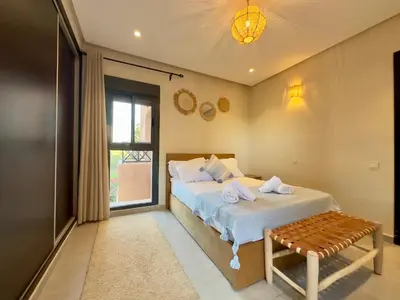 a bedroom with a bed and a bench and a window at Villa Atlas view in Marrakech