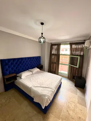 a bedroom with a blue bed and a window at Duplex Mirador Majorelle in Marrakech