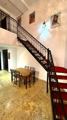 a dining room with a table and a staircase at Duplex Mirador Majorelle in Marrakech