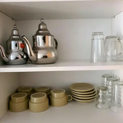 a shelf with a tea kettle and dishes on it at Appartement près du hôtel IBIS et WAZO et Marjane Mall in Marrakech