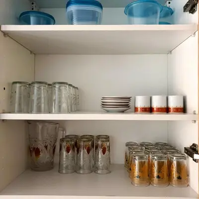 a shelf filled with glass jars and plates at Appartement près du hôtel IBIS et WAZO et Marjane Mall in Marrakech