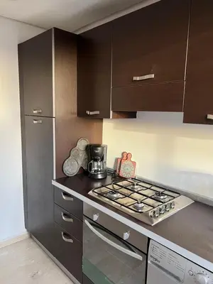 a kitchen with a stove and brown cabinets at Appartement à Marrakech Babylon 2 Hivernage in Marrakech