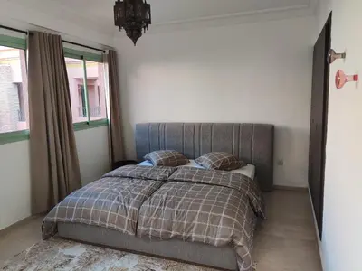 a bedroom with a bed with a blanket and two pillows at Appartement à Marrakech Babylon 2 Hivernage in Marrakech