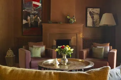a living room with a fireplace and a table with flowers at Dar Zemora in Marrakech