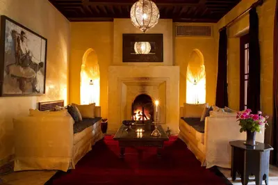 a living room with a fireplace with couches and a fire place at Dar Zemora in Marrakech