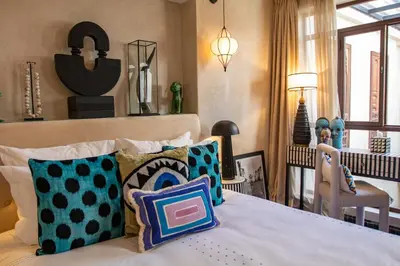 a bedroom with a bed with pillows and a dining room at Riad Lulua Exclusif 3 Chambres et Piscine Rooftop in Marrakech