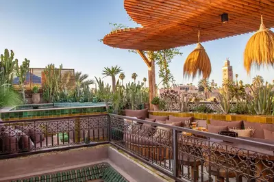 a rooftop patio with plants and a fence at Riad Lulua Exclusif 3 Chambres et Piscine Rooftop in Marrakech