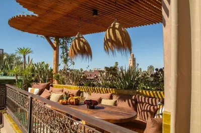 a porch with a table and chairs on a balcony at Riad Lulua Exclusif 3 Chambres et Piscine Rooftop in Marrakech