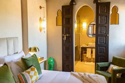 a bedroom with a bed and a bathroom with a sink at Riad Lulua Exclusif 3 Chambres et Piscine Rooftop in Marrakech