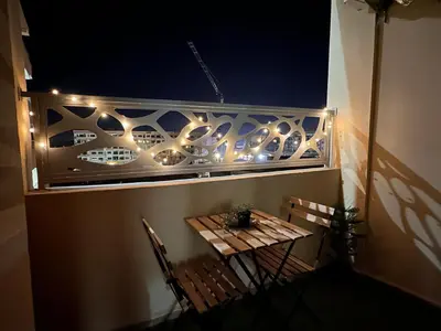 a balcony with a table and chairs and lights at Green appart Marrakech by Kamal in Marrakech