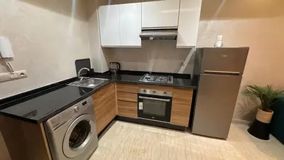 a small kitchen with a sink and a washer at Green appart Marrakech by Kamal in Marrakech
