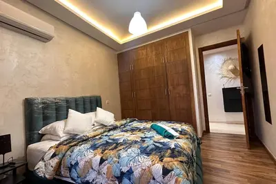 a bedroom with a bed with a comforter on it at Green appart Marrakech by Kamal in Marrakech