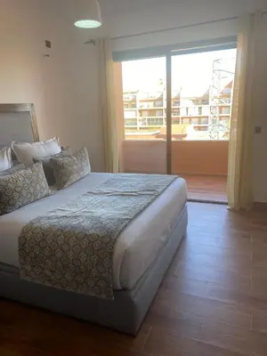 a bedroom with a bed and a large window at Appartement luxueux 38 nour 5 in Marrakech