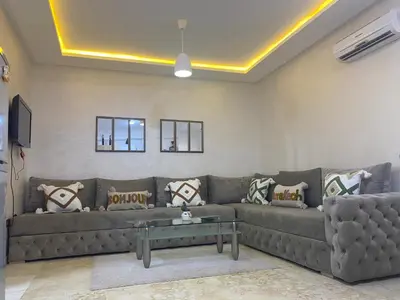 a living room with a couch and a table at Appartement luxueux 38 nour 5 in Marrakech