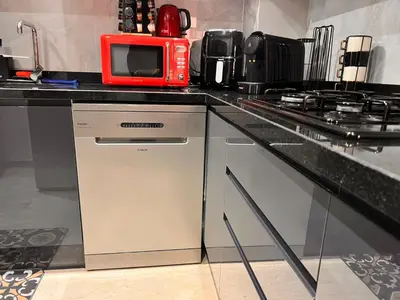 a kitchen with a dishwasher and a red microwave at Appartement de prestige Gueliz kasbel 212 in Marrakech