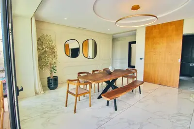 a dining room with a wooden table and chairs at Villa SELINA Luxury -5 suites , Piscine privée chauffée, sans vis à vis, calme & sureté - Padle , Family only in Marrakech