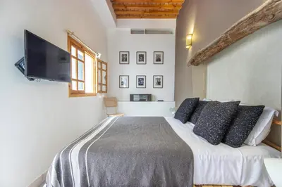 a bedroom with a bed with pillows and a flat screen tv at Riad Les Suites Marrakech in Marrakech
