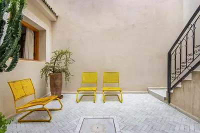 two yellow chairs sitting next to a wall at Riad Les Suites Marrakech in Marrakech