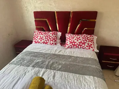 a bedroom with a bed with red and white pillows at Liton's Avenue in Marrakech