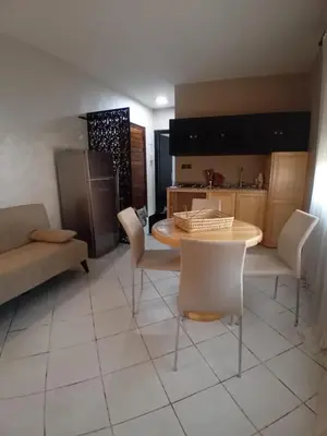 a living room with a table and chairs and a kitchen at APPARTENT 11 à GUELIZE HIVERNAGE in Marrakech