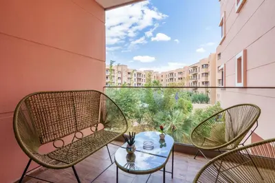 a balcony with chairs and a table with a view at Red appart in Marrakech