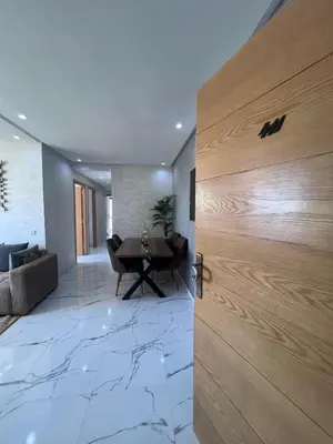 a door leading into a living room with a table at Le Paradis Balnéaire - 2 min Plage - 2 chambres in Marrakech