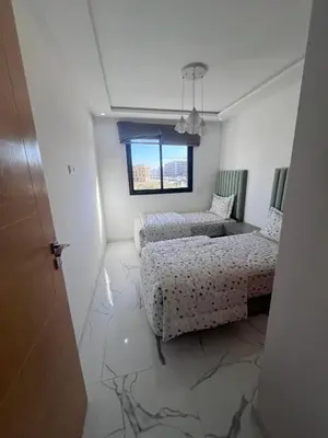 a room with two beds and a window at Le Paradis Balnéaire - 2 min Plage - 2 chambres in Marrakech