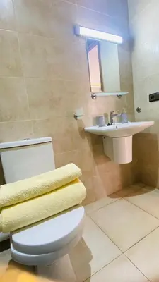 a bathroom with a white toilet and a sink at Résidence nour 5 in Marrakech