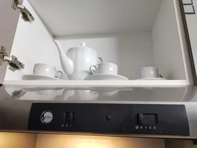 a shelf with dishes and a tea pot in a microwave at Appartement Familial à Marrakech avec des espaces verts et 5 piscines in Marrakech