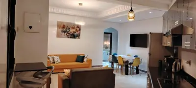 a living room with a couch and a table at Appartement Familial à Marrakech avec des espaces verts et 5 piscines in Marrakech