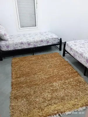 a room with two beds and a brown rug at Appartement Chic à Marrakech in Marrakech