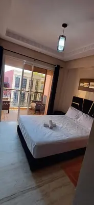 a bedroom with a large bed with a large window at Résidence hamza appartement 2 chambre in Marrakech