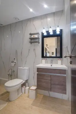 a bathroom with a toilet and a sink and a mirror at Luxury Apartment in Hivernage Marrakech in Marrakech