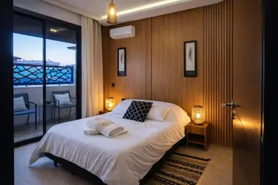 a bedroom with a large bed and a balcony at Luxury Apartment in Hivernage Marrakech in Marrakech
