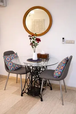 a glass table with two chairs and a mirror at Luxury Apartment in Hivernage Marrakech in Marrakech