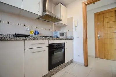 a kitchen with white cabinets and a black oven at Appart charmante au cour de marrakech l'hivernage in Marrakech