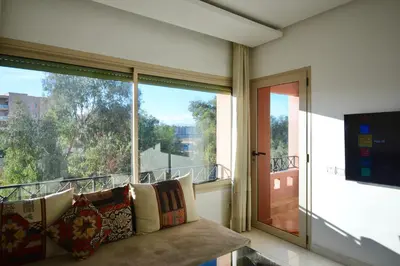 a living room with a couch and a large window at Appart charmante au cour de marrakech l'hivernage in Marrakech