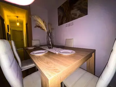 a wooden table with two plates and a vase on it at L'Havre de Paix - Proxi Centre - 2 Chambres in Marrakech