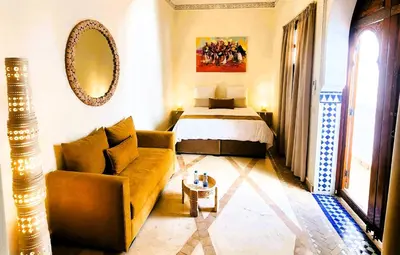 a living room with a bed and a couch at Riad Vilamoura & SPA in Marrakech