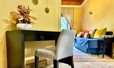a chair sitting next to a fireplace in a living room at Palmeraie vue piscine 3 in Marrakech