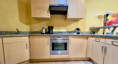 a kitchen with white cabinets and an oven at Palmeraie vue piscine 3 in Marrakech