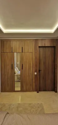 a bedroom with wooden walls and a door with a mirror at Firstwood Chic Apartment Hivernage in Marrakech