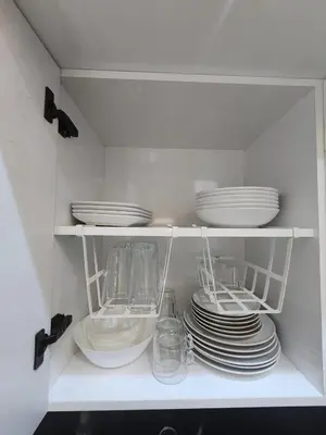 a white cabinet with plates and dishes in it at Firstwood Chic Apartment Hivernage in Marrakech