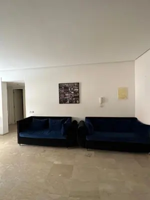 a living room with two blue couches and a wall at Apparemment 1 chambre salon à coté de la gare guéliz 16 in Marrakech