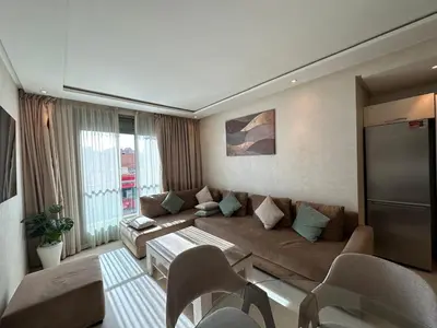 a living room with a couch and a tv at Appartement 2 chambres salon à coté de carré éden Perles3 in Marrakech