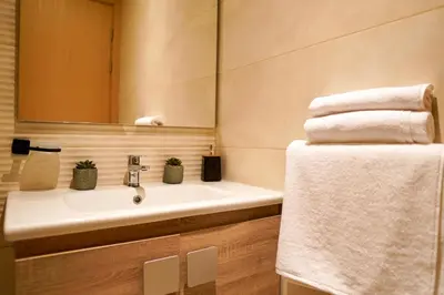 a bathroom with a sink and a mirror and towels at Appartement 2 chambres salon à coté de carré éden Perles3 in Marrakech
