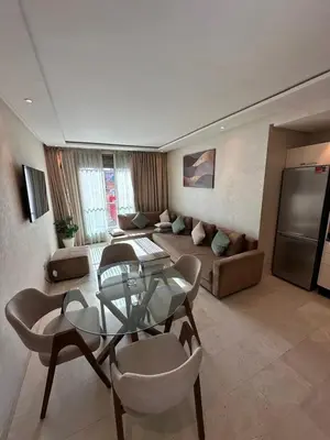 a living room with a glass table and chairs at Appartement 2 chambres salon à coté de carré éden Perles3 in Marrakech