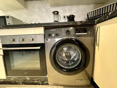 a washing machine in a kitchen next to a stove at Appartement 2 chambres salon à coté de carré éden 10 in Marrakech